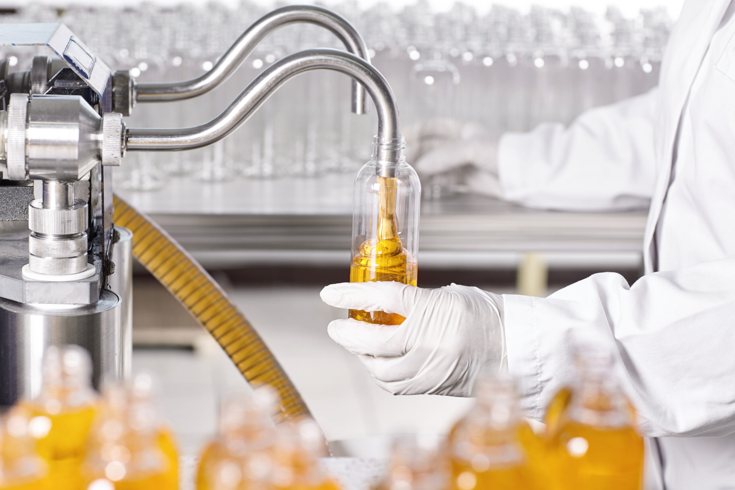 factory worker extracting oil to bottle.